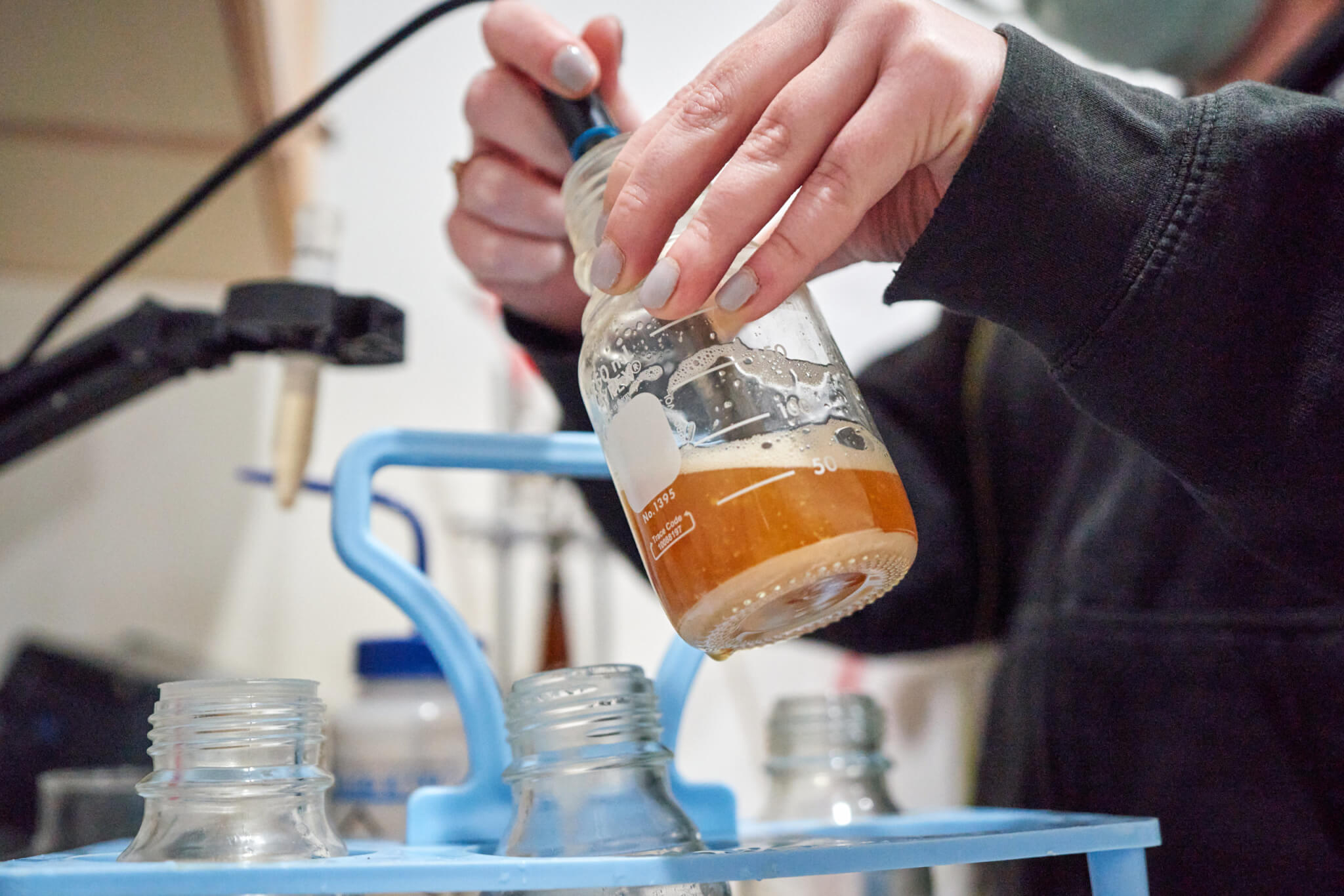 A lab technician measures out a sample of beer for analysis inside the Cigar City Brewing quality control lab.